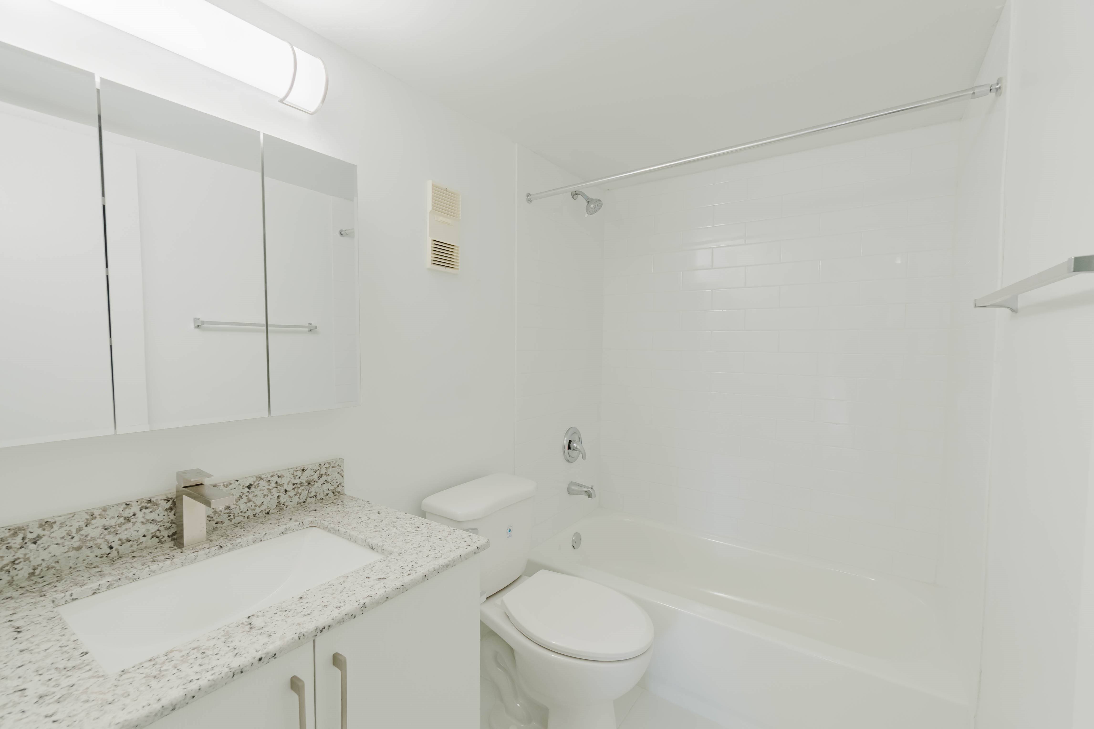 A white bathroom with a sink, toilet and bathtub.